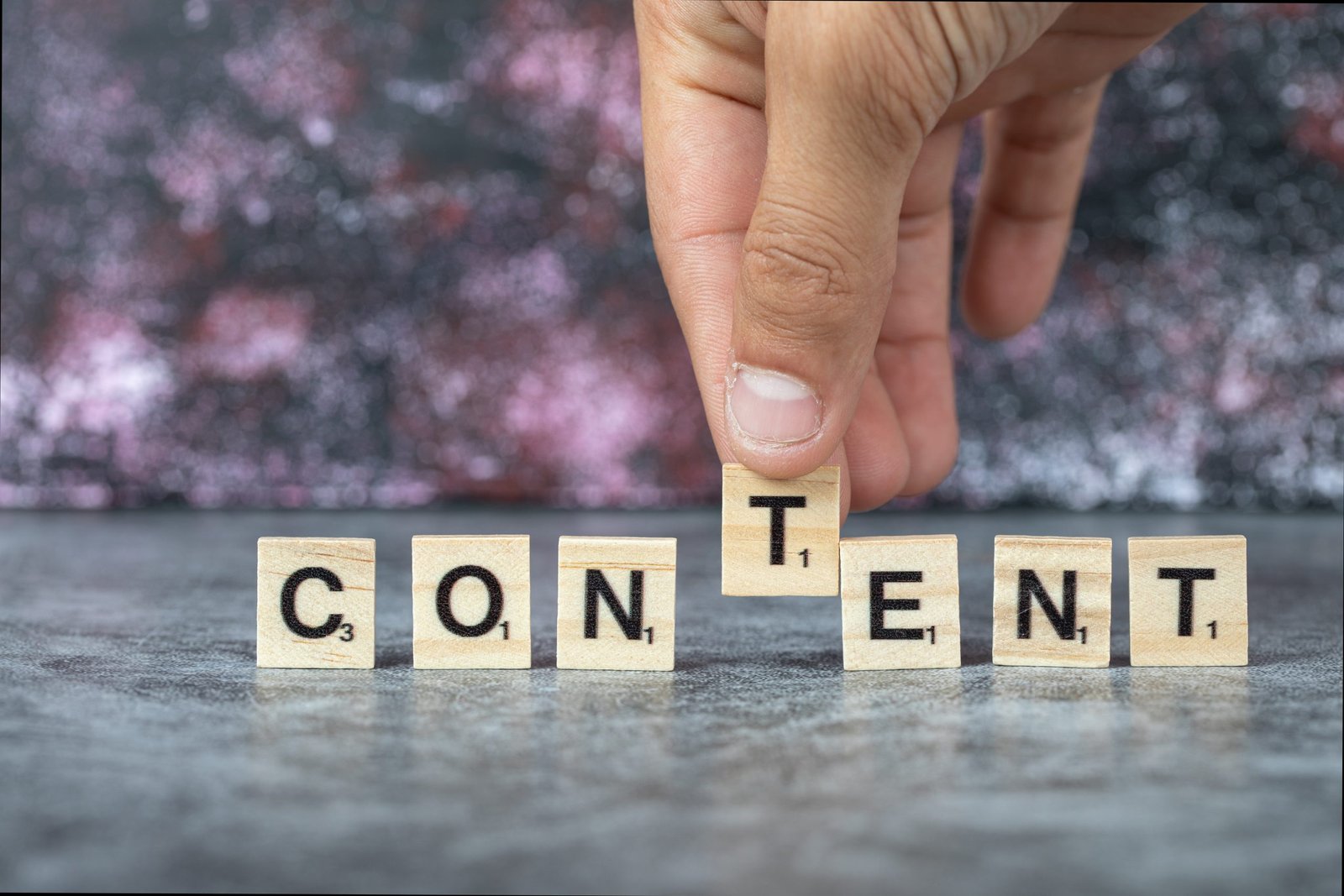Content writing with black letters on wooden dices on blue background letras content en piezas de scrabble para la agencia con más experiencia en branded content de Madrid