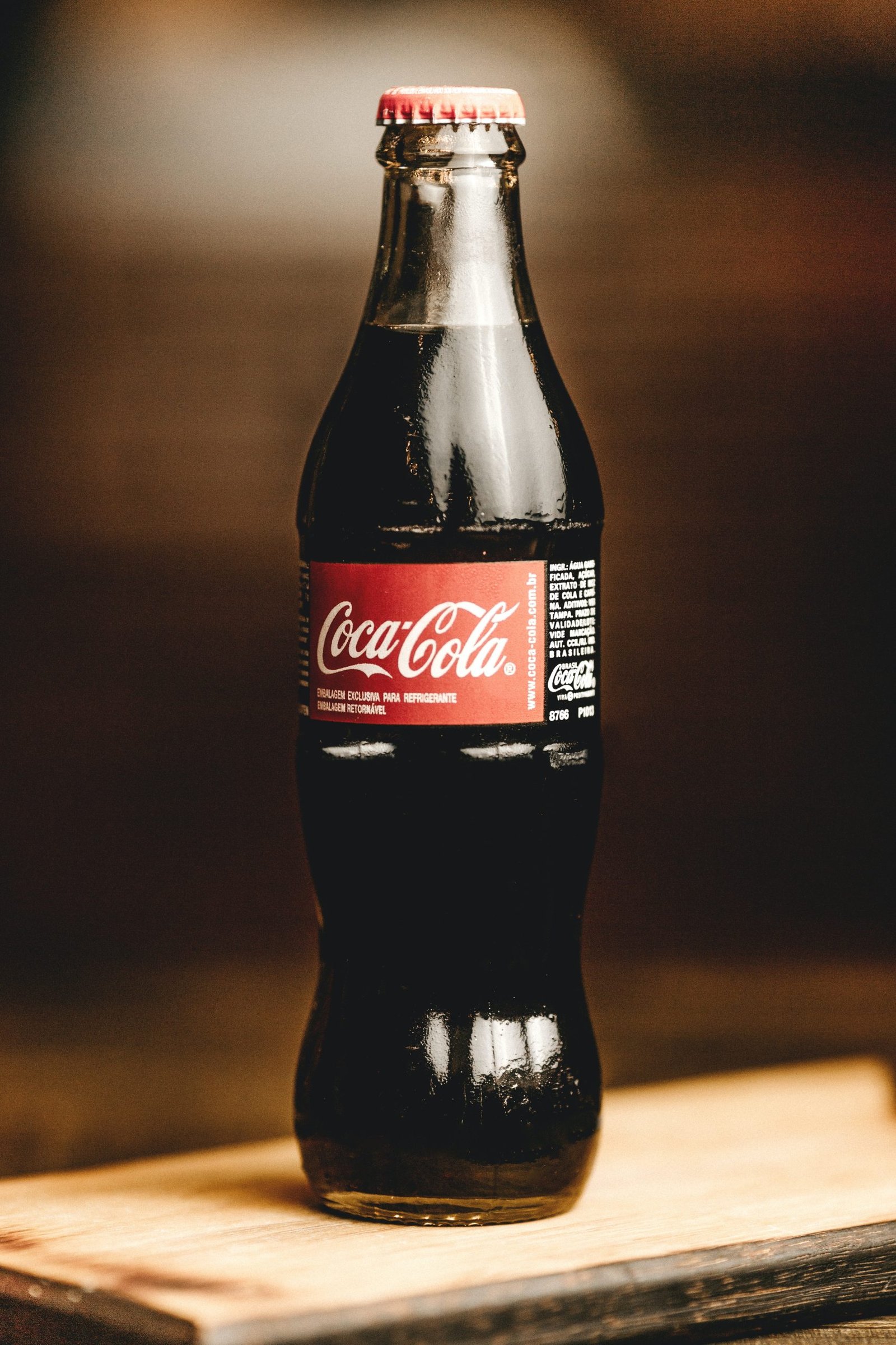 jonathan-borba-yZOfNnI2PA0-unsplash botella de coca cola cristal sobre fondo oscuro detras, ejemplo de branding famoso